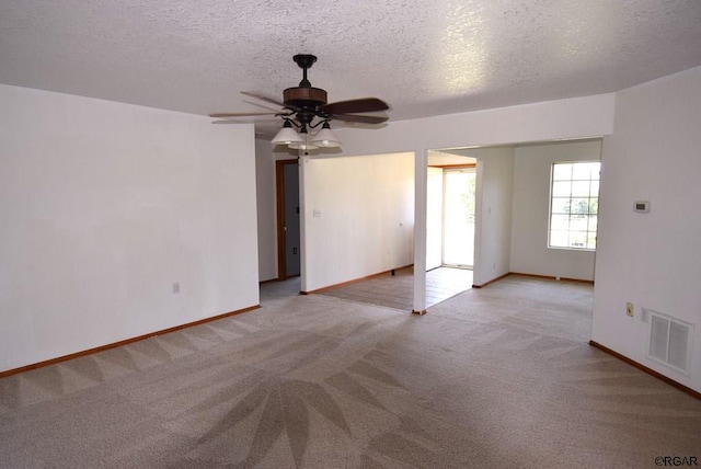 carpeted spare room featuring ceiling fan and a textured ceiling