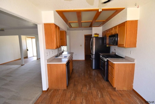 kitchen with appliances with stainless steel finishes, dark hardwood / wood-style flooring, and sink