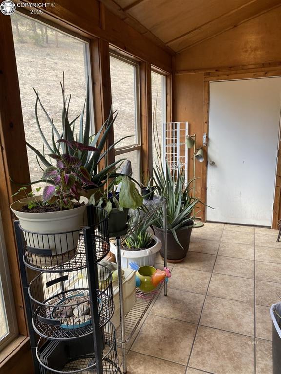 sunroom / solarium featuring wood ceiling, vaulted ceiling, and a wealth of natural light