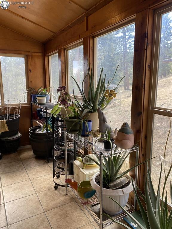 sunroom featuring vaulted ceiling and wooden ceiling