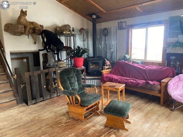 bedroom with wood-type flooring and a wood stove