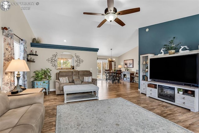 living room with ceiling fan, baseboards, wood finished floors, and vaulted ceiling