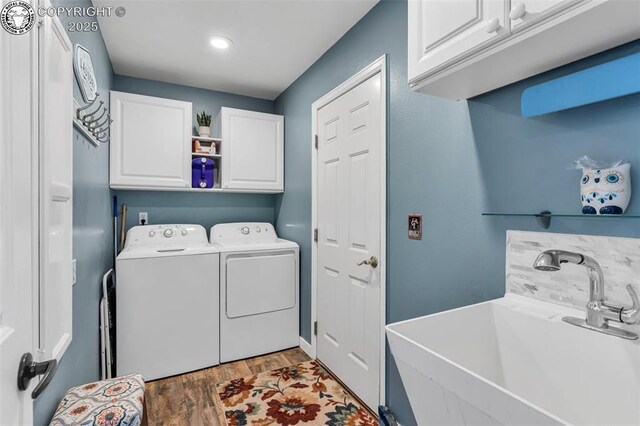 laundry room featuring separate washer and dryer, wood finished floors, cabinet space, and a sink