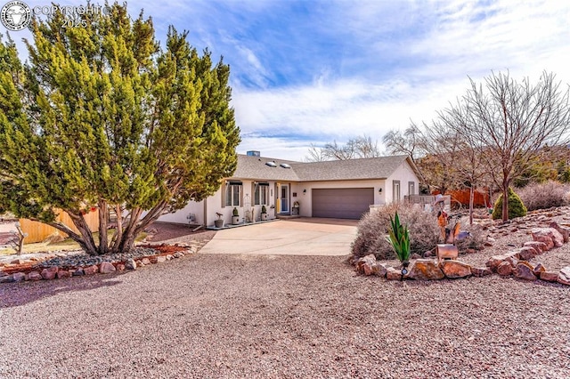 ranch-style house featuring a garage, concrete driveway, and stucco siding