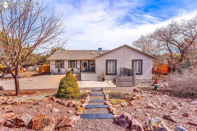 ranch-style home with a patio area, stucco siding, and fence