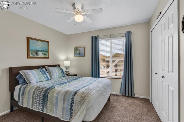 carpeted bedroom with a closet, baseboards, and a ceiling fan