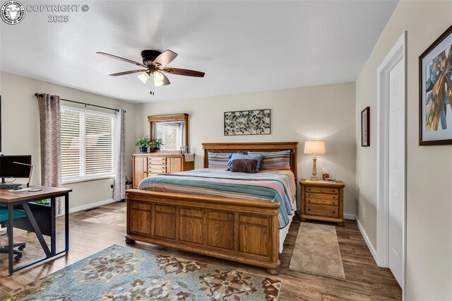 bedroom with wood finished floors, baseboards, and ceiling fan