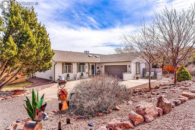 ranch-style home with stucco siding, driveway, and a garage