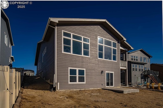 rear view of house featuring a patio and fence