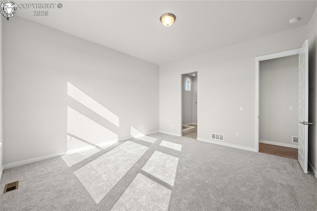 unfurnished bedroom with carpet, visible vents, and baseboards