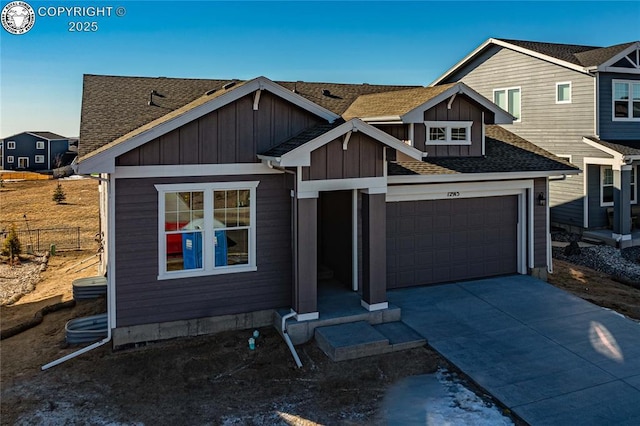 view of front of house featuring board and batten siding, concrete driveway, roof with shingles, and a garage