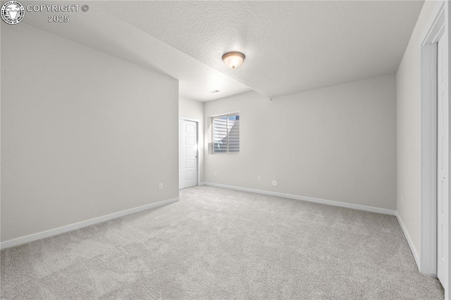 carpeted spare room with baseboards and a textured ceiling