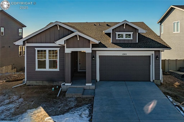 view of front of property featuring an attached garage, fence, driveway, roof with shingles, and board and batten siding