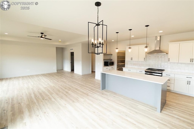 kitchen with light countertops, wall chimney exhaust hood, tasteful backsplash, and stainless steel appliances