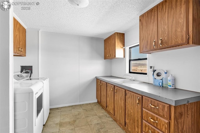 interior space featuring light countertops, brown cabinetry, a sink, a textured ceiling, and independent washer and dryer