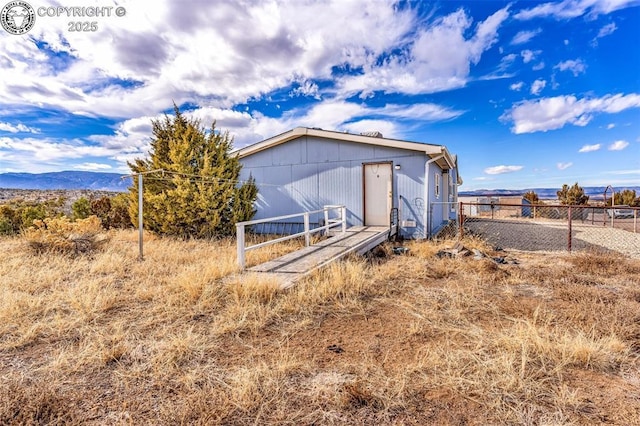 view of outbuilding featuring fence and a mountain view