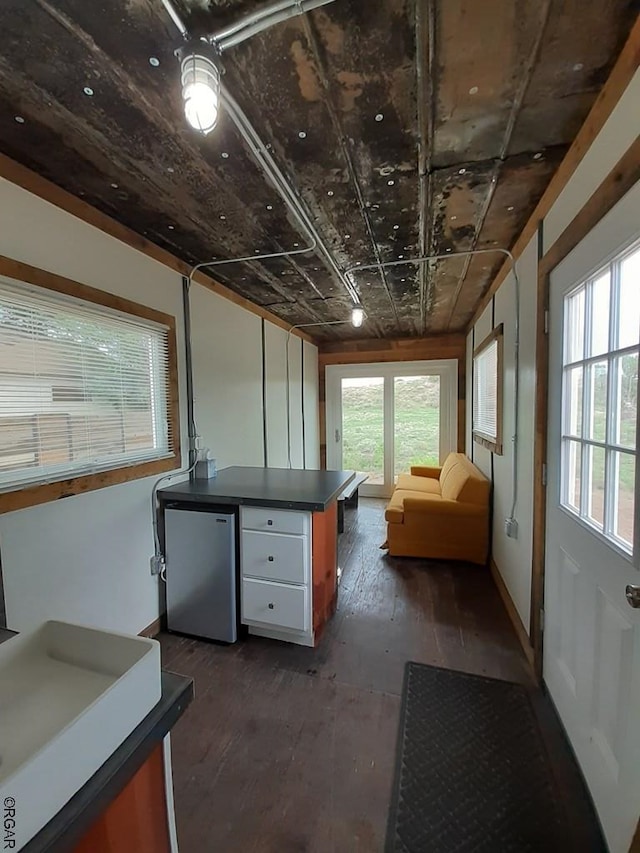 interior space featuring stainless steel fridge, dark hardwood / wood-style flooring, and a wealth of natural light