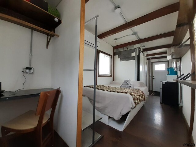 bedroom with beamed ceiling and multiple windows