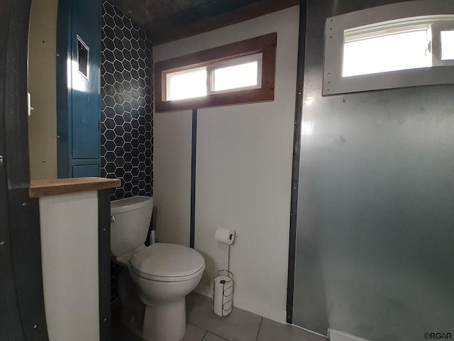 bathroom featuring tile patterned flooring, plenty of natural light, and toilet