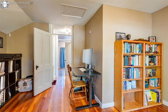 hall with hardwood / wood-style flooring and vaulted ceiling