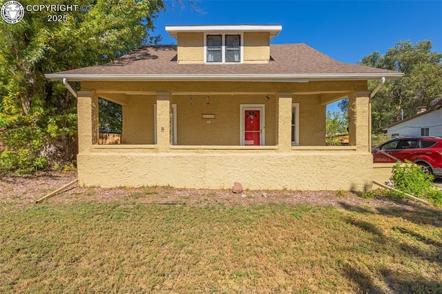 view of front of house with covered porch and a front yard