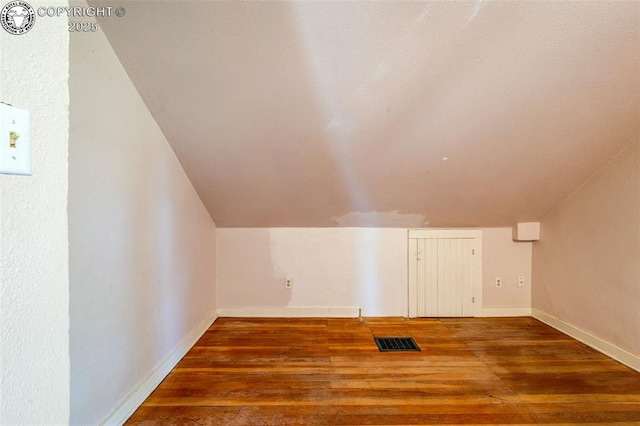 additional living space with lofted ceiling and dark hardwood / wood-style floors