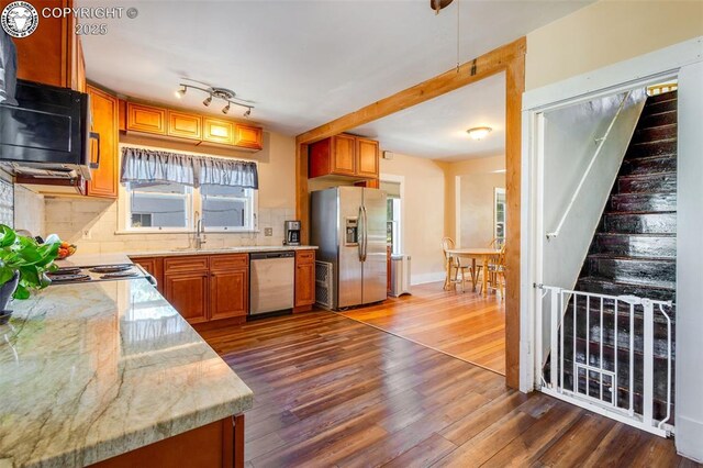 kitchen featuring sink, backsplash, dark wood-type flooring, and stainless steel appliances