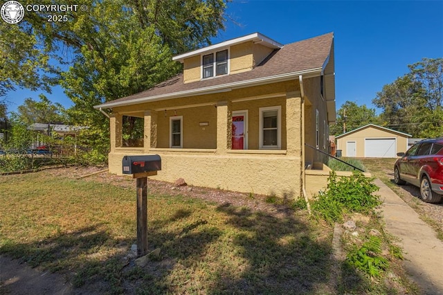 bungalow with a garage, an outdoor structure, a front yard, and covered porch