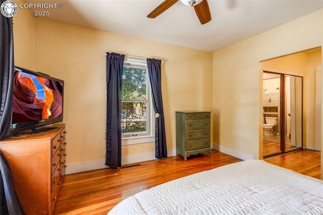 bedroom featuring connected bathroom, wood-type flooring, a closet, and ceiling fan