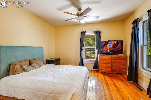 bedroom with light hardwood / wood-style floors and ceiling fan