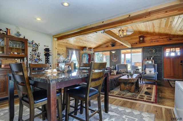 dining space with wood ceiling, vaulted ceiling with beams, dark hardwood / wood-style flooring, and wood walls