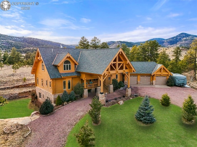 324 Elk View Ct, Canon City, CO 81212 - view of front of house featuring a garage, a front yard, stone siding, a mountain view, and driveway