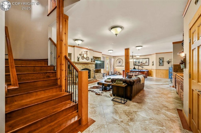 324 Elk View Ct, Canon City, CO 81212 - living room with ornamental molding, stairway, a wainscoted wall, wood walls, and a fireplace with raised hearth