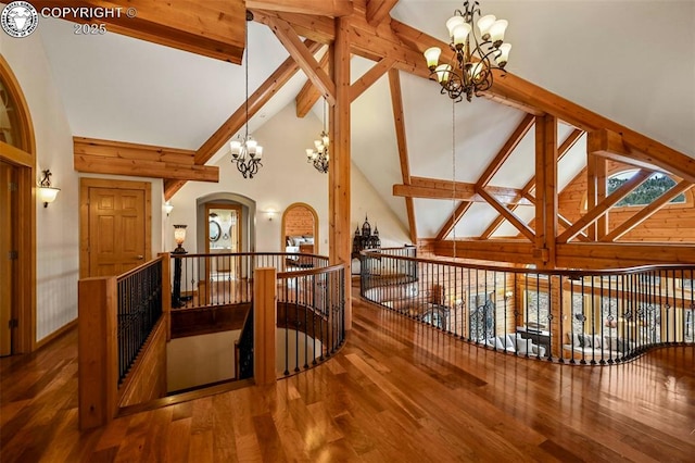 324 Elk View Ct, Canon City, CO 81212 - interior space featuring an inviting chandelier, an upstairs landing, beam ceiling, arched walkways, and wood finished floors