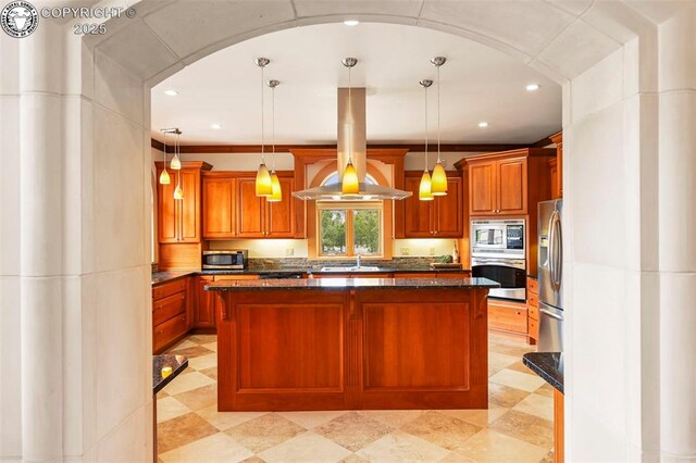 324 Elk View Ct, Canon City, CO 81212 - kitchen with brown cabinetry, dark stone countertops, appliances with stainless steel finishes, a center island, and hanging light fixtures