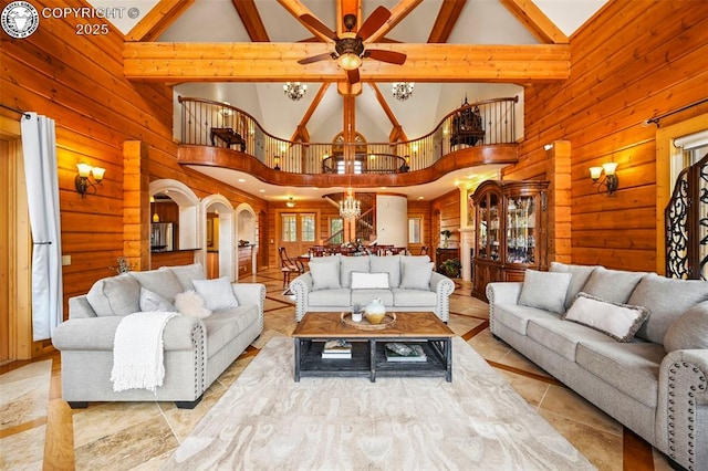 324 Elk View Ct, Canon City, CO 81212 - living room featuring ceiling fan with notable chandelier, wood walls, and high vaulted ceiling