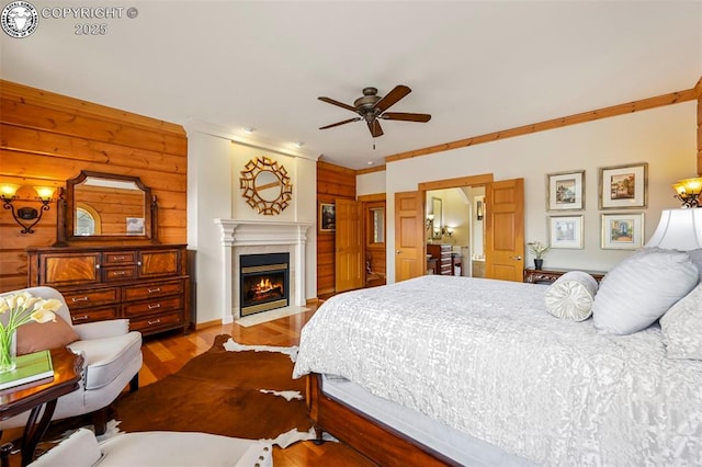 324 Elk View Ct, Canon City, CO 81212 - bedroom with a fireplace with flush hearth, wood finished floors, wooden walls, and ornamental molding