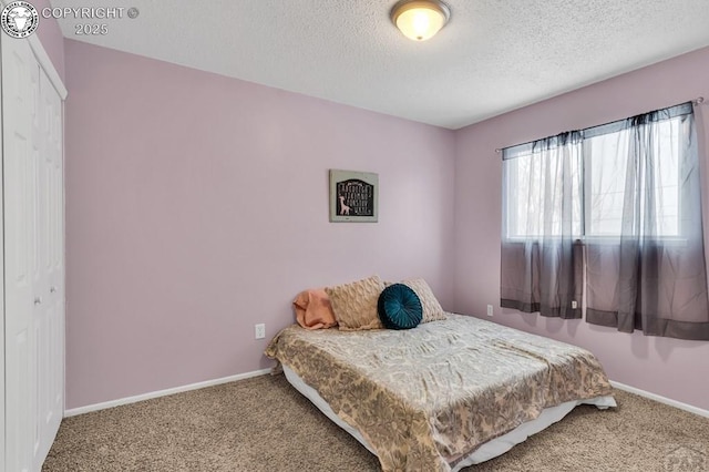 carpeted bedroom featuring a closet and a textured ceiling