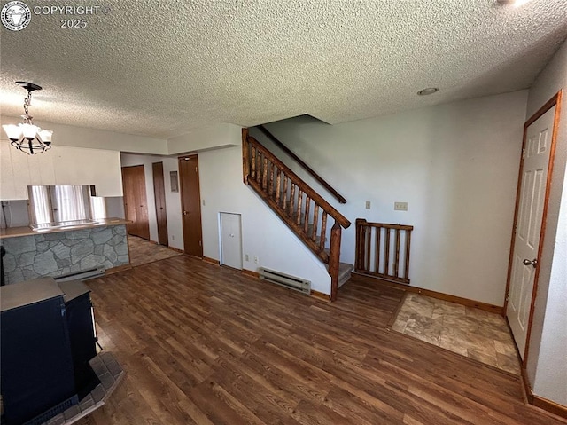 9 Granada Ct Unit 5, Westcliffe, CO 81252 - unfurnished living room featuring wood finished floors, a textured ceiling, a chandelier, stairway, and a baseboard radiator