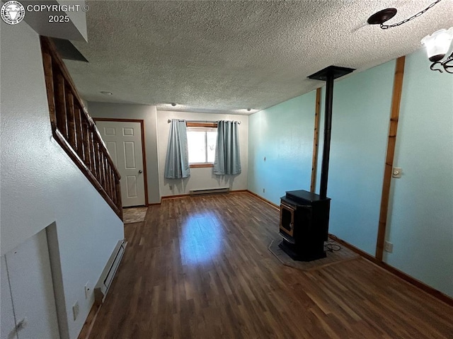 9 Granada Ct Unit 5, Westcliffe, CO 81252 - unfurnished living room featuring wood finished floors, baseboard heating, stairs, a textured ceiling, and a wood stove