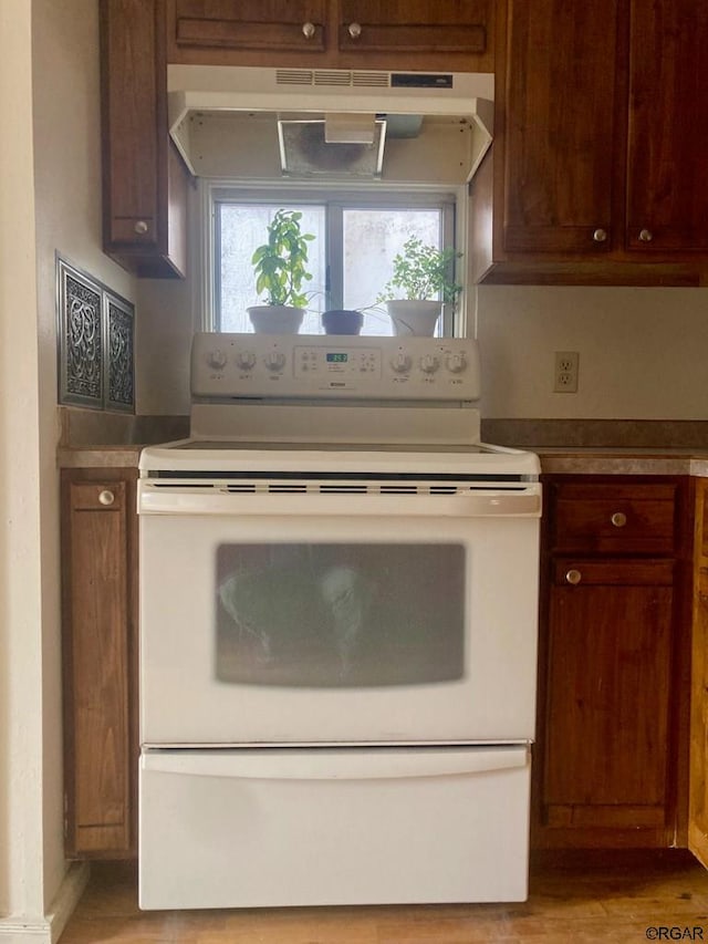 kitchen with white electric stove and light hardwood / wood-style floors