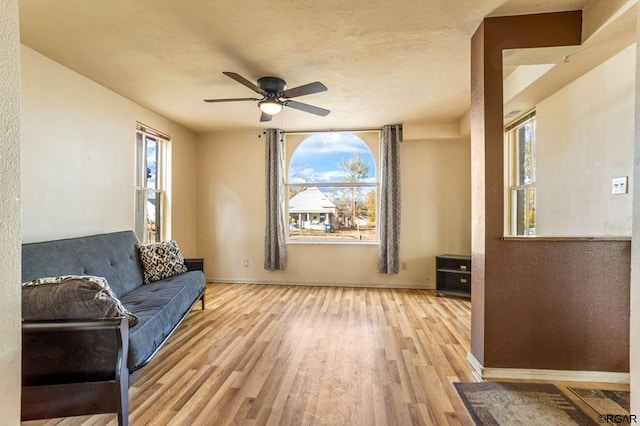 sitting room with ceiling fan, a healthy amount of sunlight, and light wood-type flooring