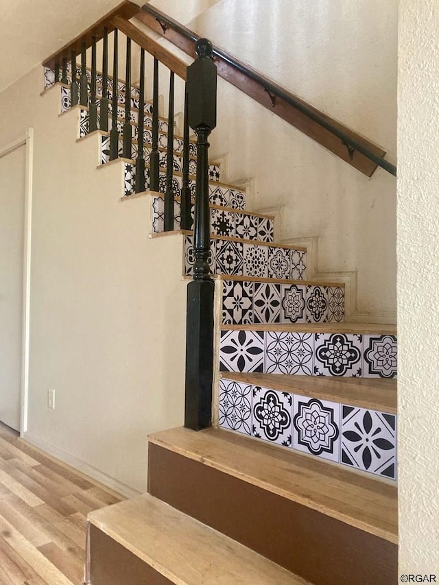 staircase with hardwood / wood-style flooring