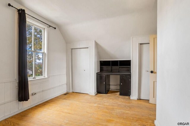 bonus room with a wealth of natural light, vaulted ceiling, and light wood-type flooring