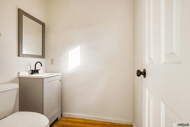 bathroom with vanity, hardwood / wood-style flooring, and toilet