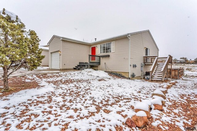 snow covered property featuring a garage