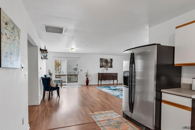 kitchen featuring white cabinetry, stainless steel fridge, and light hardwood / wood-style floors