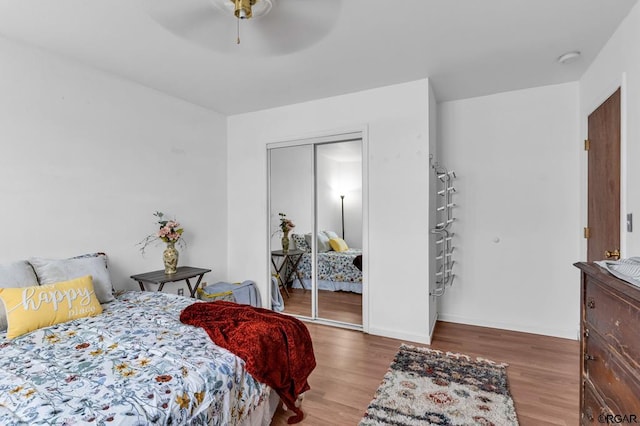 bedroom with hardwood / wood-style floors, ceiling fan, and a closet