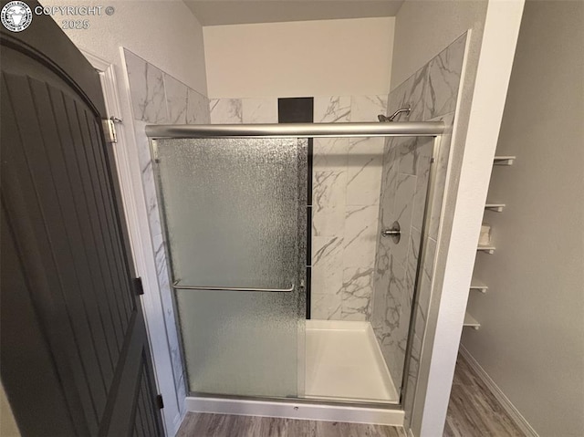 bathroom with hardwood / wood-style flooring and walk in shower