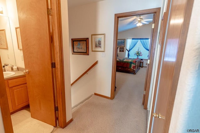 hallway with light carpet and lofted ceiling